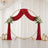 Elegant wedding backdrop with red velvet drapes, gold circle arch, and floral accents