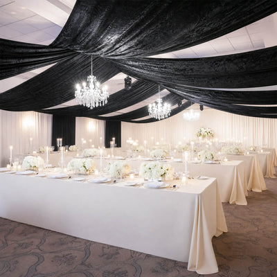 Elegant black and white wedding reception with chandeliers and floral table decor