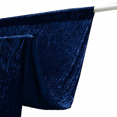 Dark blue velvet curtain draped on a white rod, close-up texture and folds