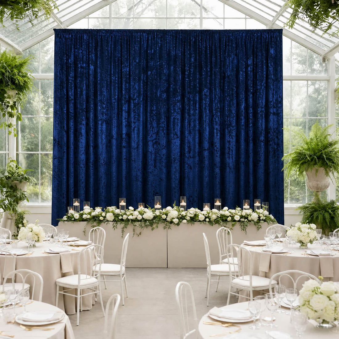 Elegant wedding reception with navy blue backdrop and white floral table decor