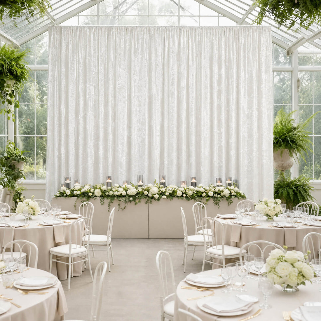 Elegant white wedding reception in a glass greenhouse with floral decor
