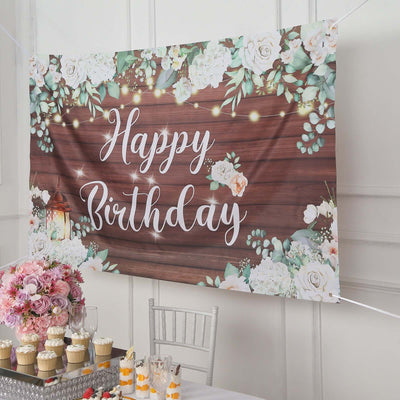 Happy Birthday banner with floral design on wooden backdrop.