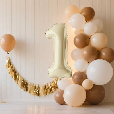 Gold number one balloon with a cluster of balloons in beige and white.