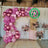 Pink balloon arch with floral arrangements, eco-friendly decoration setup.