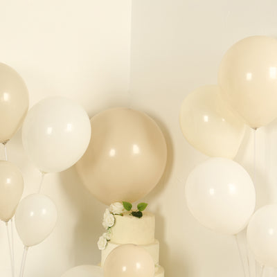Cream and white balloons arranged around a decorated cake.