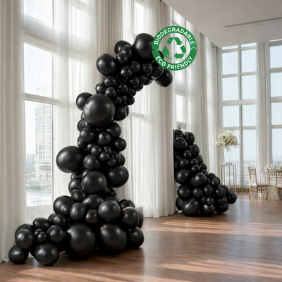 Black biodegradable balloons arranged in elegant archways for events.
