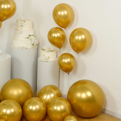 Gold balloons in various sizes, arranged with decorative cake stands.