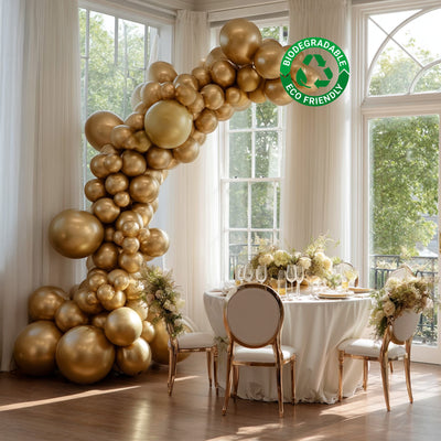 Gold biodegradable balloon arch decoration in an elegant dining setting.
