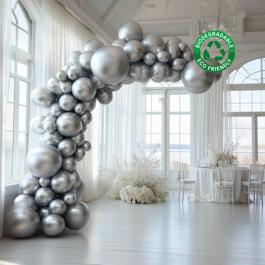 Silver biodegradable balloon arch in a bright event space. Eco-friendly decoration.
