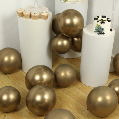 Gold balloons and cupcakes on white pedestals in a festive setting.