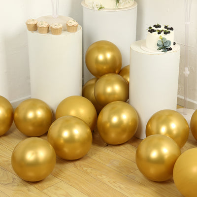 Gold balloons scattered around a cake and cupcakes at a festive celebration.