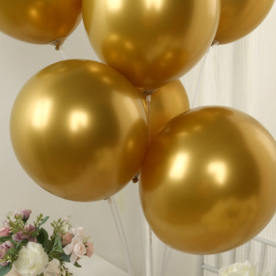 Gold balloons clustered together with a floral arrangement in the background.