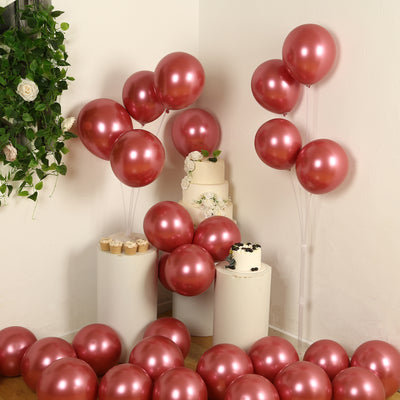 Rose gold balloons in a festive setting with a cake and decorations.