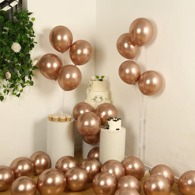 Rose gold balloons in a festive setup with cake and decor.