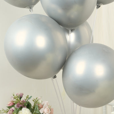 Silver balloons clustered together with pastel flowers in the background.