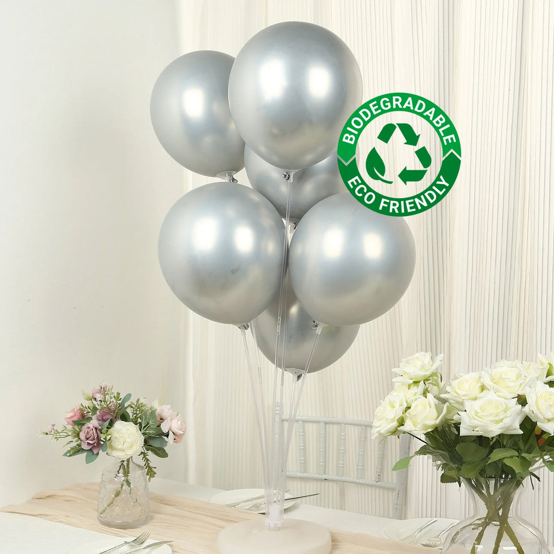 Silver biodegradable balloons on a table with flowers. Eco-friendly decor option.
