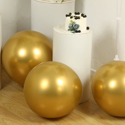 Gold decorative balls and a small cake with blueberries on a pedestal.
