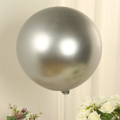 Silver balloon on a stick with flowers in the background.