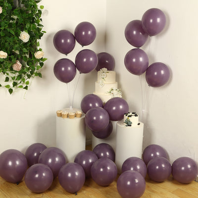 Purple balloons with a white cake and cupcakes for a festive celebration.