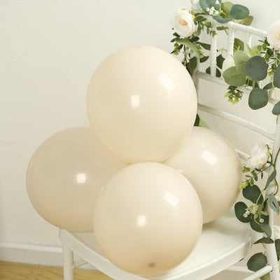 Cream balloons arranged on a white chair with greenery accents.