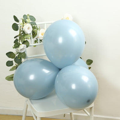 Blue balloons arranged with greenery and flowers on a chair.