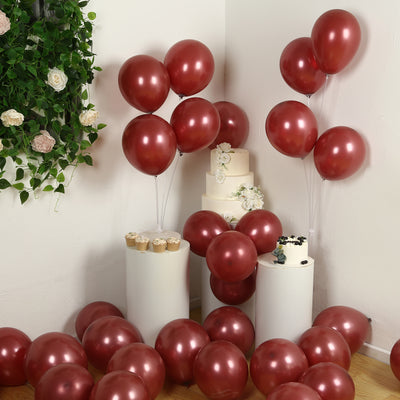 Red balloons and cake set up for a festive celebration in a decorated space.