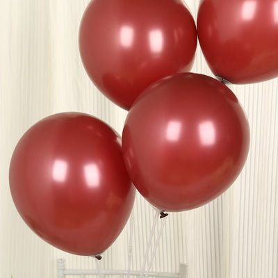 Bunch of glossy burgundy balloons on a plain background.