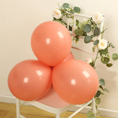 Peach balloons arranged on a chair with floral accents.