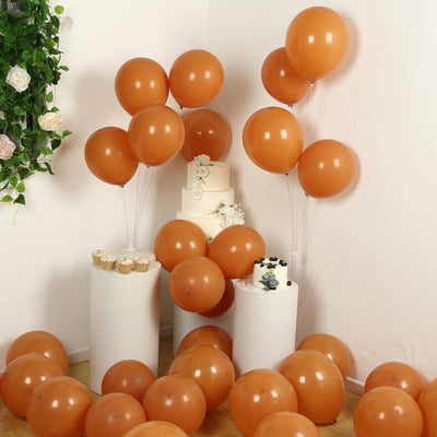 Orange balloons and cakes arranged in a festive celebration setup.