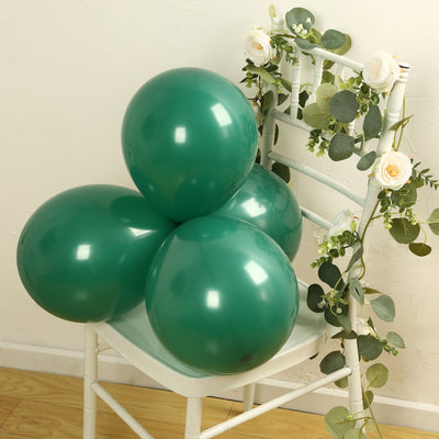 Green balloons arranged on a white chair with floral decor.