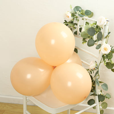 Peach balloons arranged on a chair with floral decor.