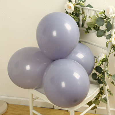 Purple balloons arranged on a chair with greenery accents.