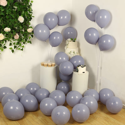 Purple balloons scattered around a party setup with cake and decorative elements.