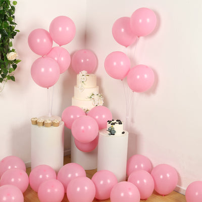 Pink balloons and cake arranged for a festive celebration.