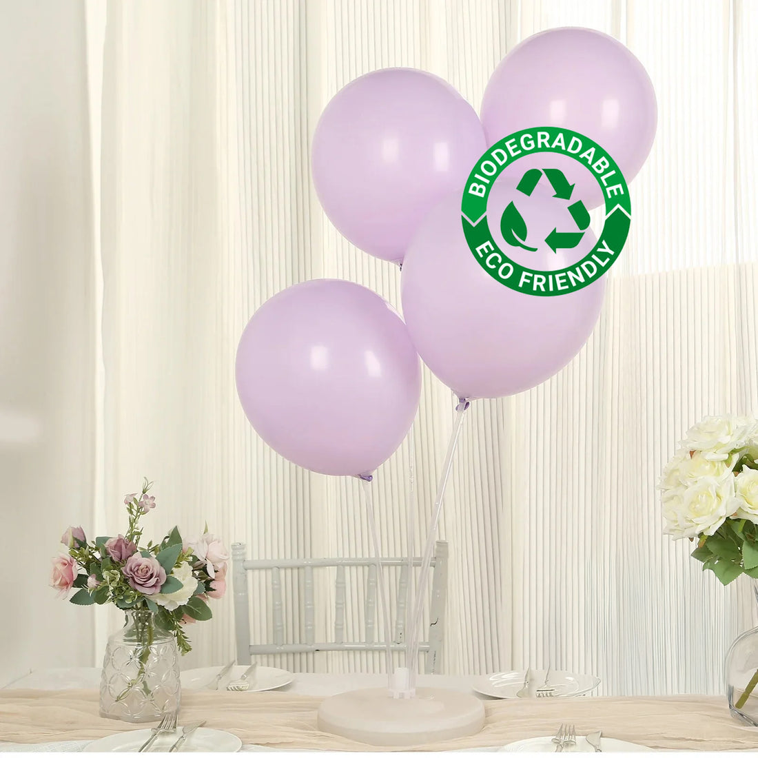 Purple biodegradable balloons on a table with flowers, eco-friendly label included.
