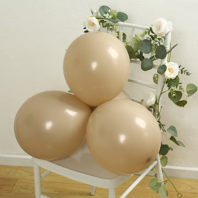 Brown balloons arranged on a chair with greenery and flowers.