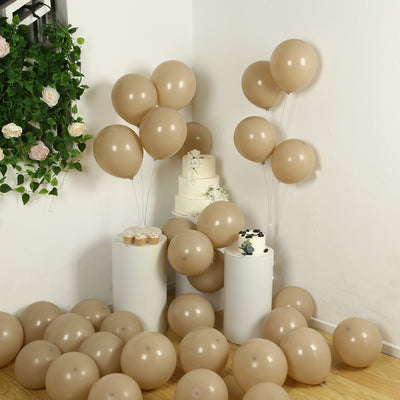 Tan balloons with a cake and cupcakes in a festive setting.