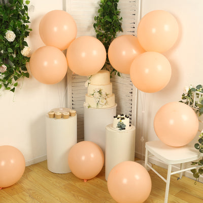Peach balloons arranged around a wedding cake and decor in a festive setting.