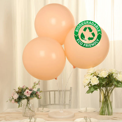 Peach biodegradable balloons with eco-friendly label on a table setting.
