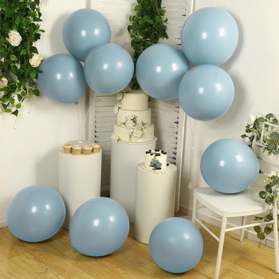 Blue balloons arranged around a white cake display in a decorated setting.