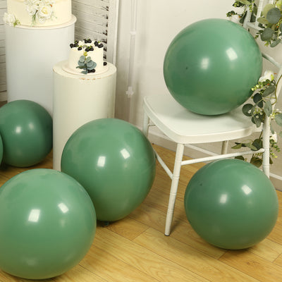 Green balloons arranged around a chair in a styled setting.