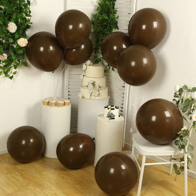 Brown balloons arranged with a cake and pastries in a decorated setting.