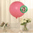 Pink biodegradable balloon with eco-friendly label on a decorated table.