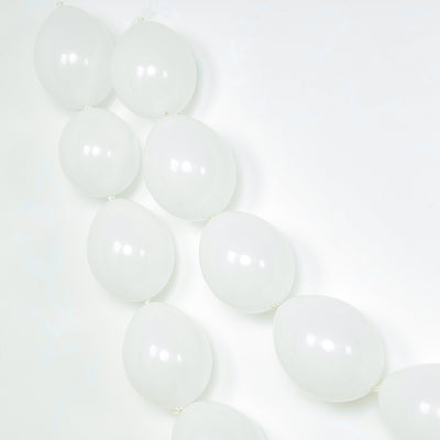 White balloons in a decorative arrangement on a plain background