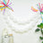 White balloons and colorful decorations for a festive celebration backdrop.