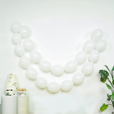White balloons arranged in a decorative arch against a plain background.