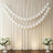 White balloons arranged in a decorative display with floral arrangements on either side.