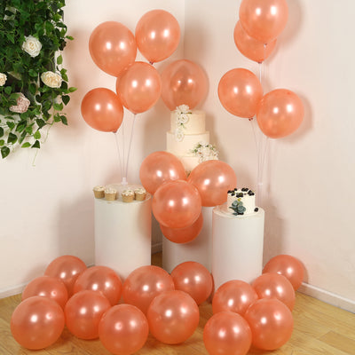 Peach balloons with a cake and cupcakes in a decorated setting.