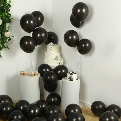 Black balloons with cake and cupcakes in a festive setup.