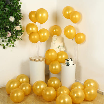 Golden balloons arranged for a festive celebration with cake and decorative elements.